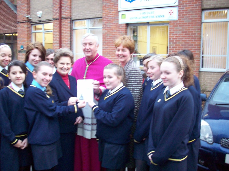 Girls, Archbishop and Headteacher standing in front of school