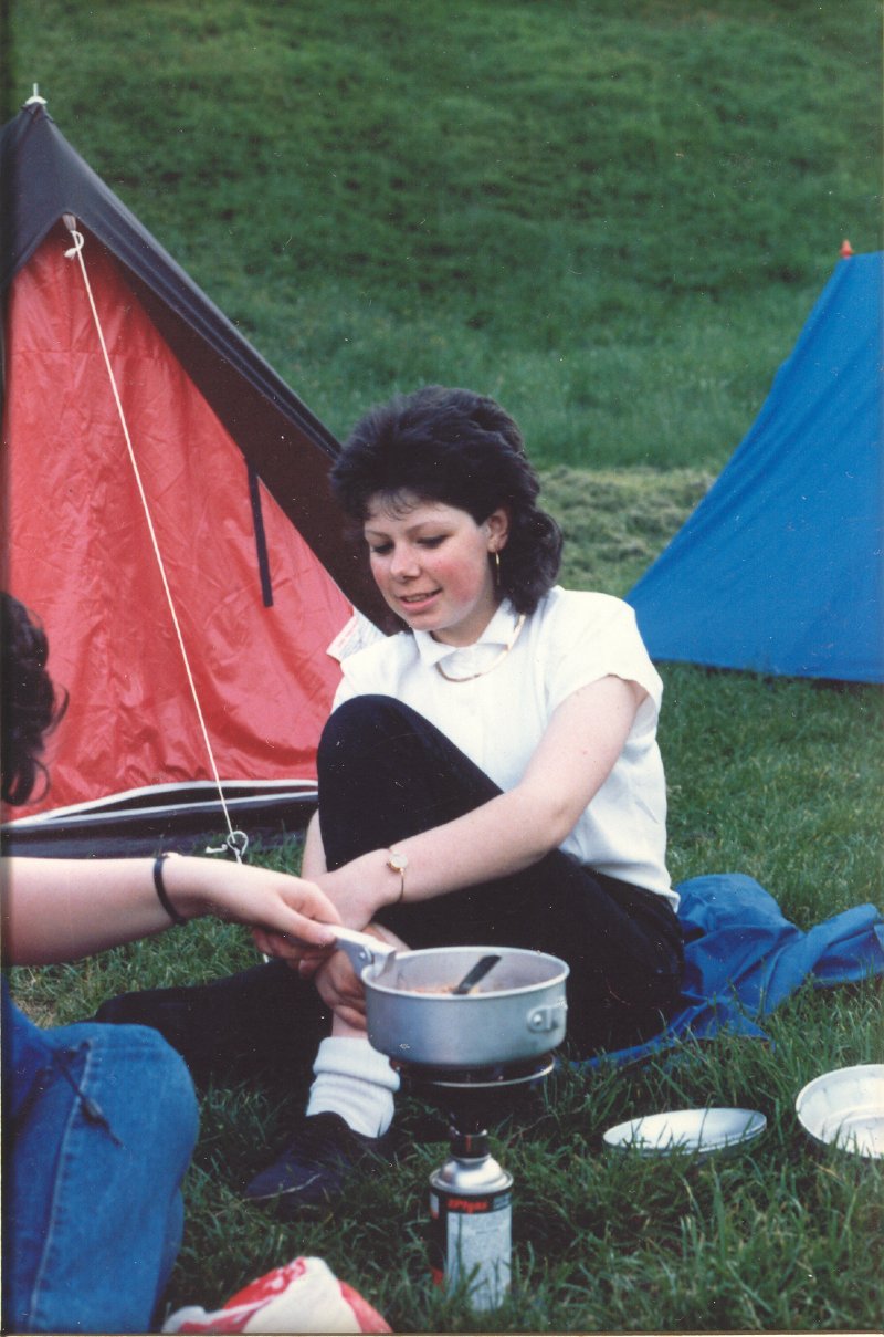 Girl sitting on grass next to tent