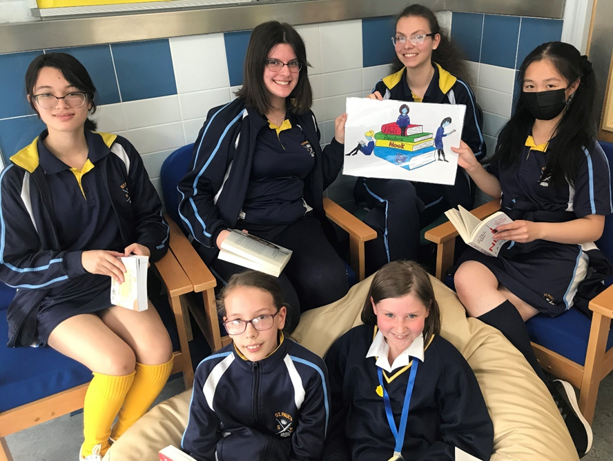 Girls sitting down holding books